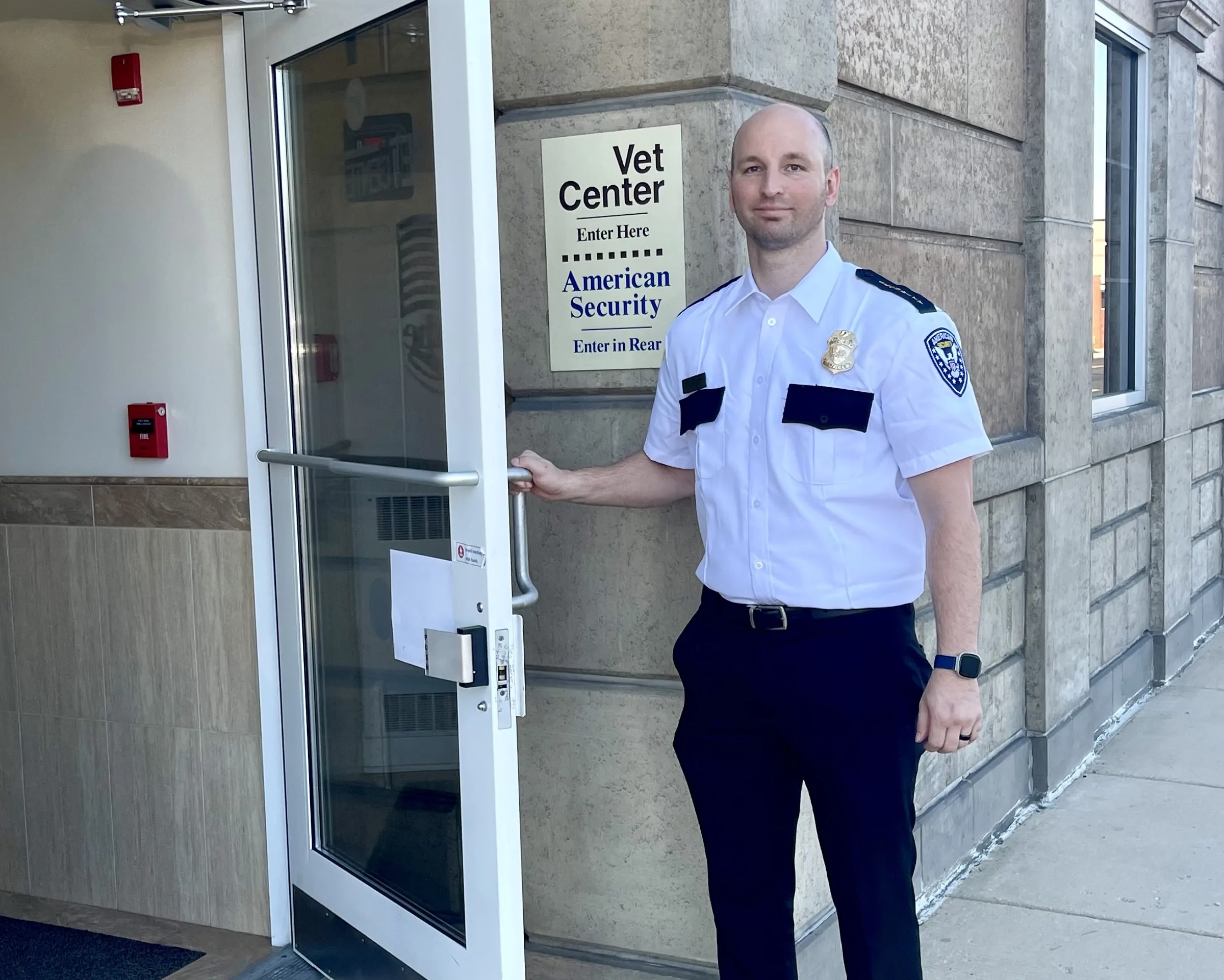 American security guard holding open the door to our office