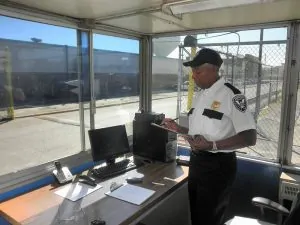 American security guard guarding in his office writing on checklist