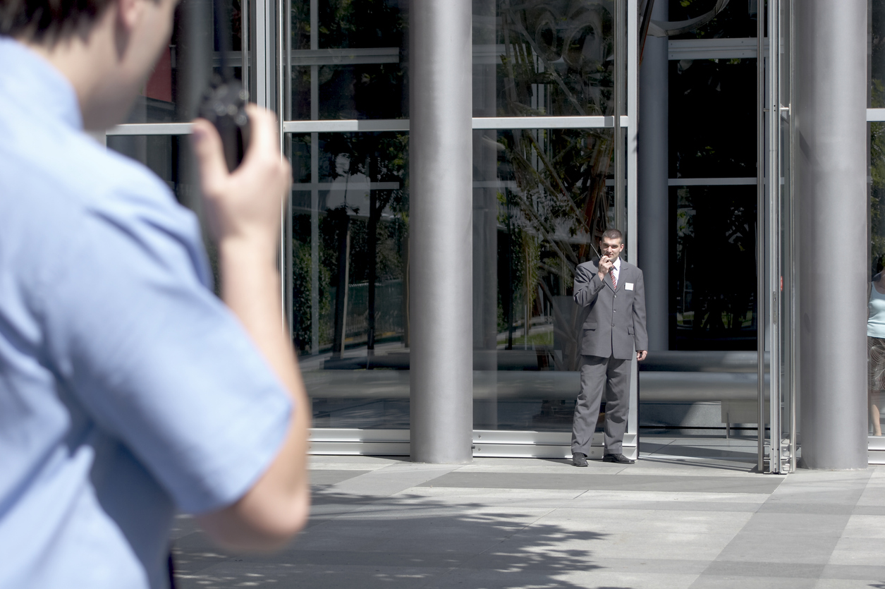 two security guards communicating via walkie talkie outside the hotel